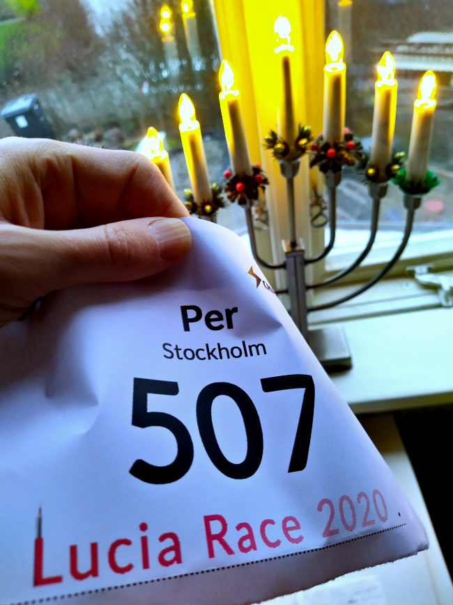 LUCIA RACE nummerlapp framför ett fönster med en adventsljusstake