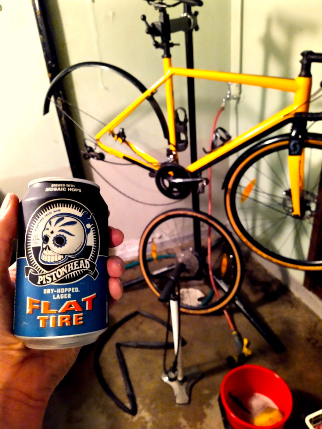 En burk Flat tire i handen framför cykelmek och cykeltvätt