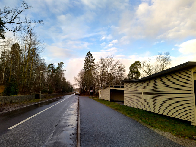 Garagelängor jämte trottar och bilväg med blå himmel i bakgrunden
