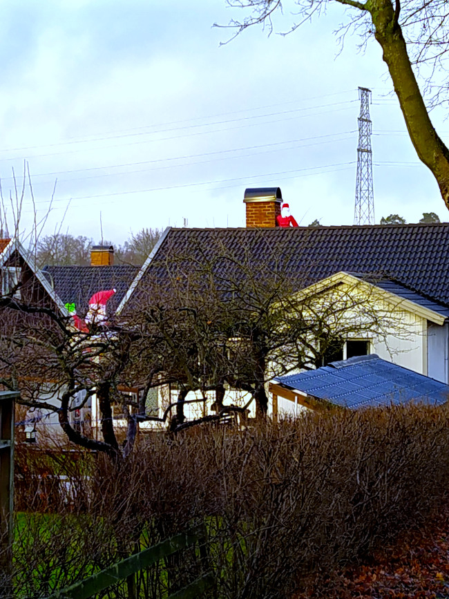 Hjultomte sittandes vid skorsten med en stor hjultomte mellan husen