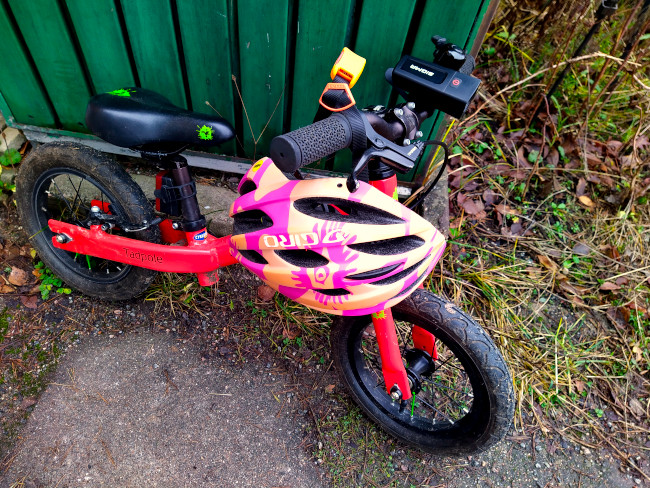 Springcykel lutad mot en vägg och med med en hjälm hängande från styret