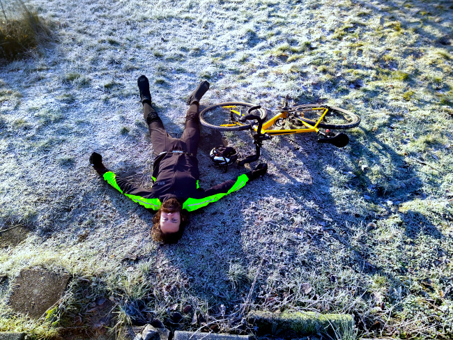 Per efter målgång utslagen på marken jämte sin cykel